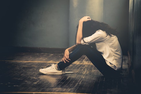upset teenager sitting in hallway
